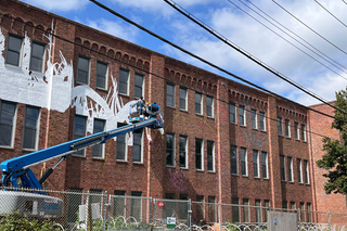 Using a safety lift for painting the murals due to height.