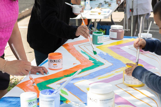 Three artists painting a pattern at a community paint day.