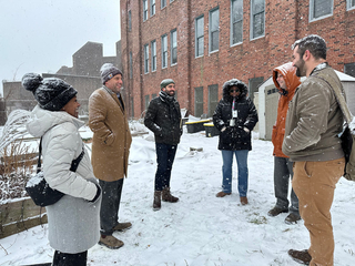 A group of 6 people in the winter on the Initial site visit to the Goffe St Armory